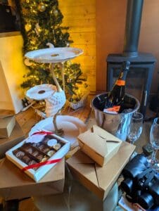 Swan Lodge dressed with a Christmas tree by the log burner with afternoon tea and prosecco on ice waiting for the couple to arrive