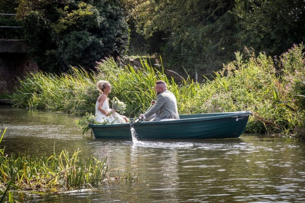 A bride and groom enjoying a private moment of fun and laughter while rowing a long the beautiful Chesterfield Canal, a unique moment at our elopement wedding venue.