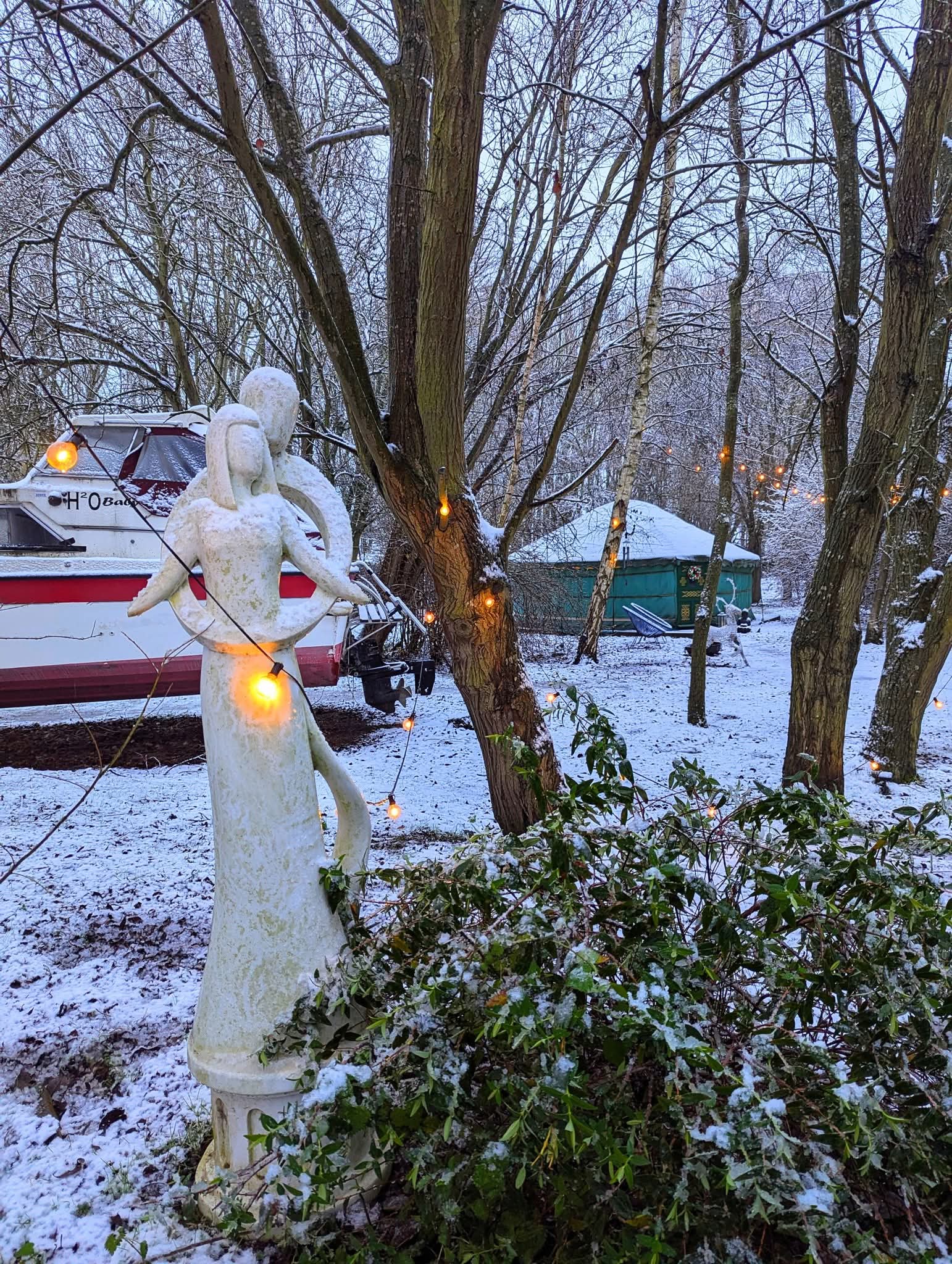 The woodland is covered in snow at Hawthorn Hideaway and the stone couple in an embrace greet you to the entrance of the woodland for romantic hot tub Christmas breaks.