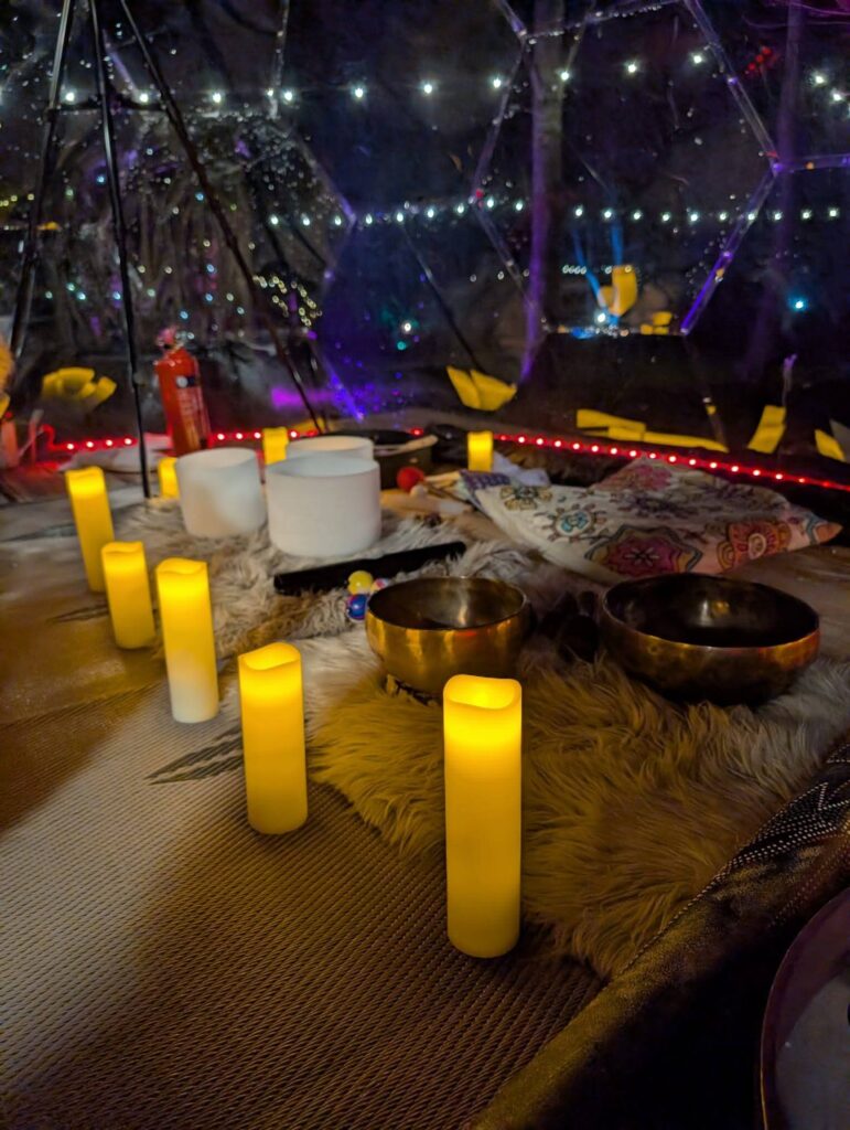 The night sky is lit with colours and festoon light in the rainbow garden while in the dome for two candles give off a warm glow. Drums and bowls lay on fur throws on the floor, ready for a soothing late night sound bath for two.. Romantic wellness at its best.