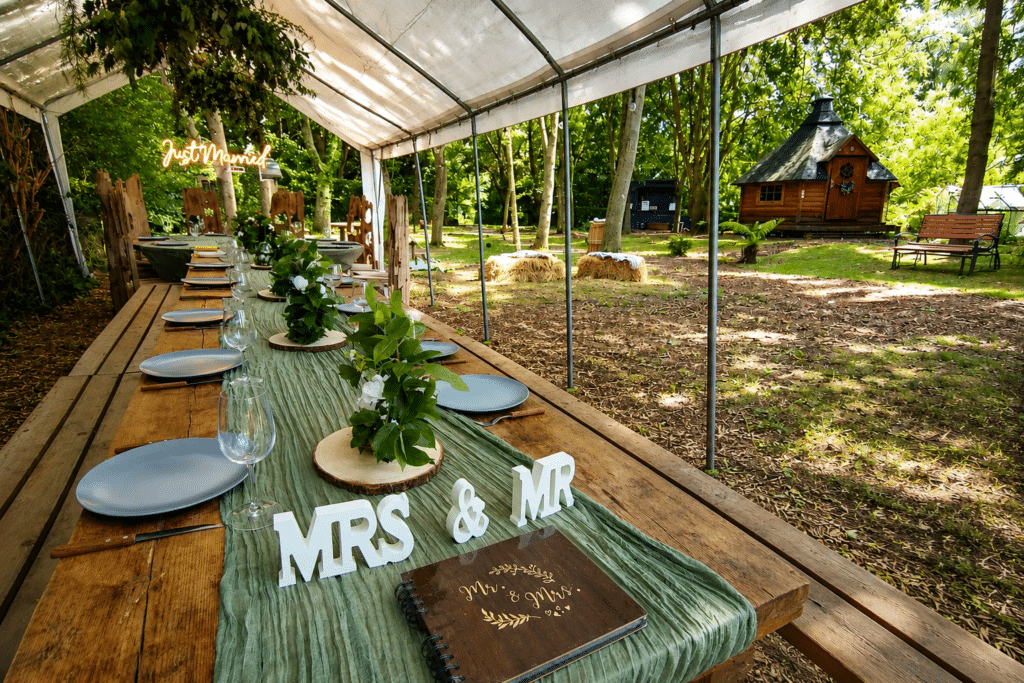 Intimate woodland wedding BBQ feast with marquee dining and BBQ cabin at Hawthorn HIdeaway