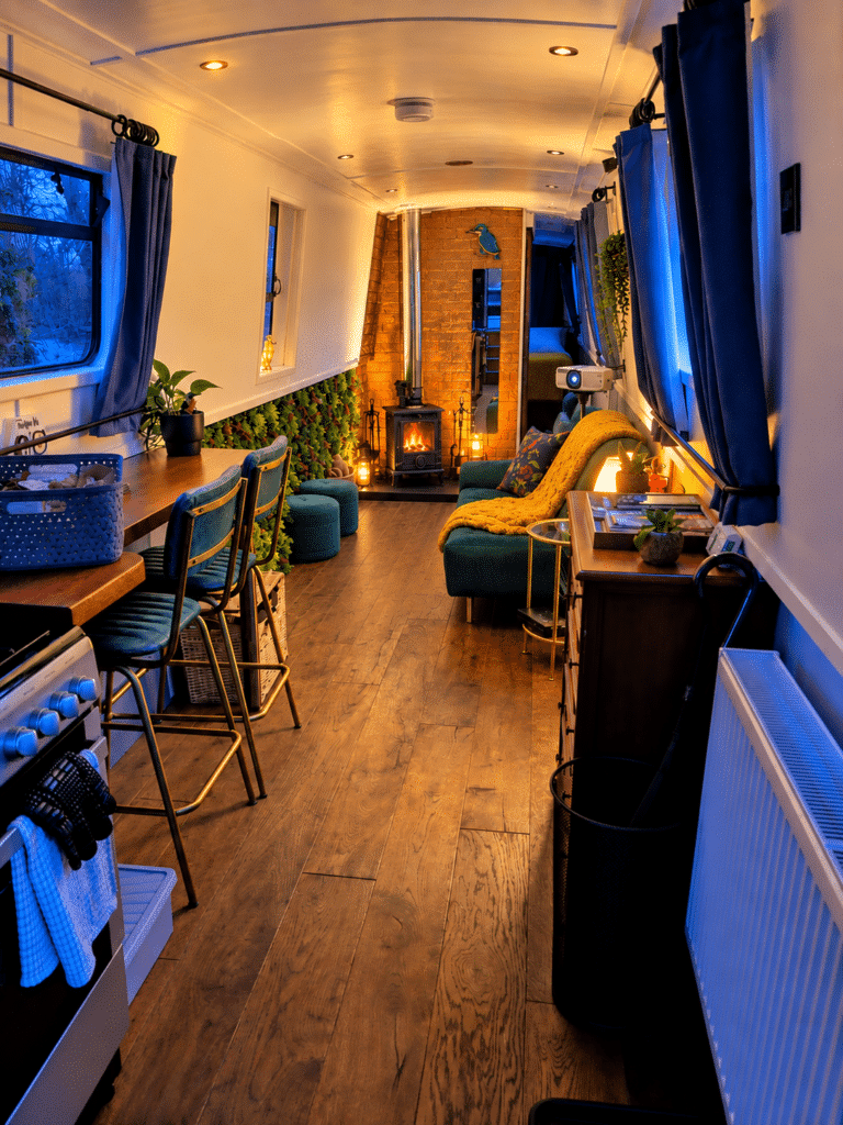 Cosy interior of Kingfisher Narrowboat with log burner and projector at Hawthorn Hideaway, a romantic couples getaway.